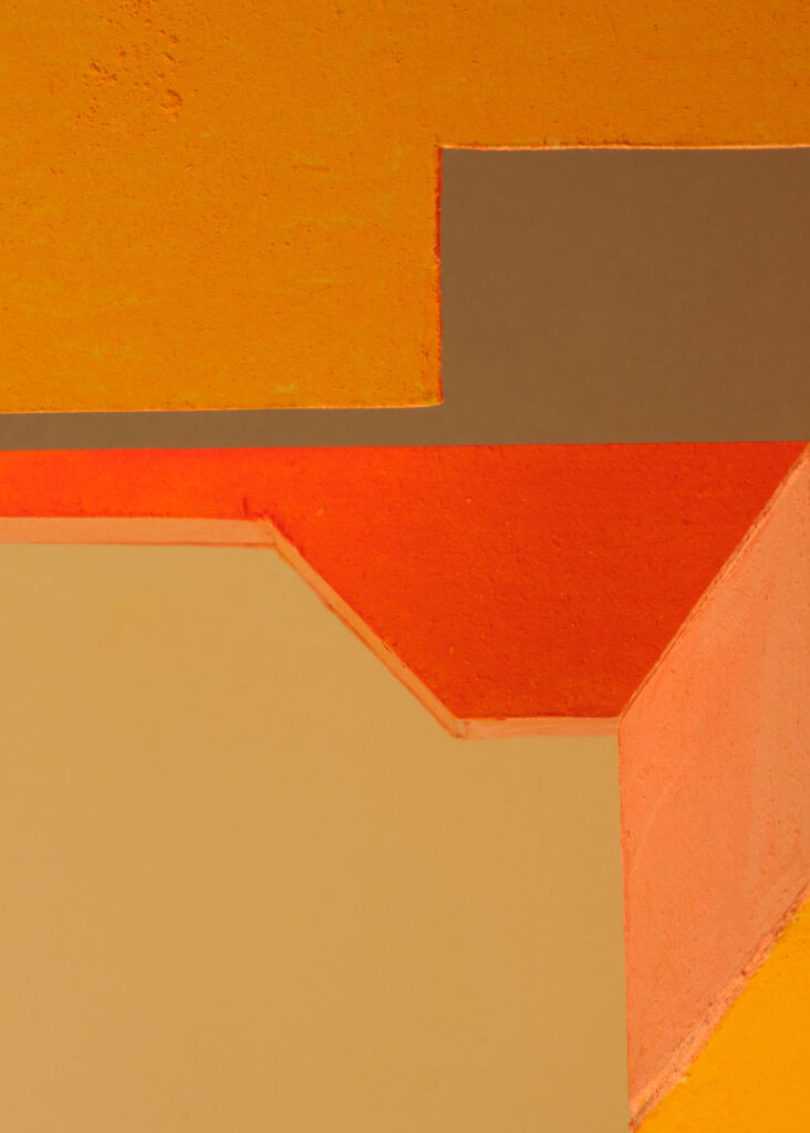 abstract colour study with geometric plaster forms in orange, pink, blue and yellow exploring shifting colour relationships and spatial perception