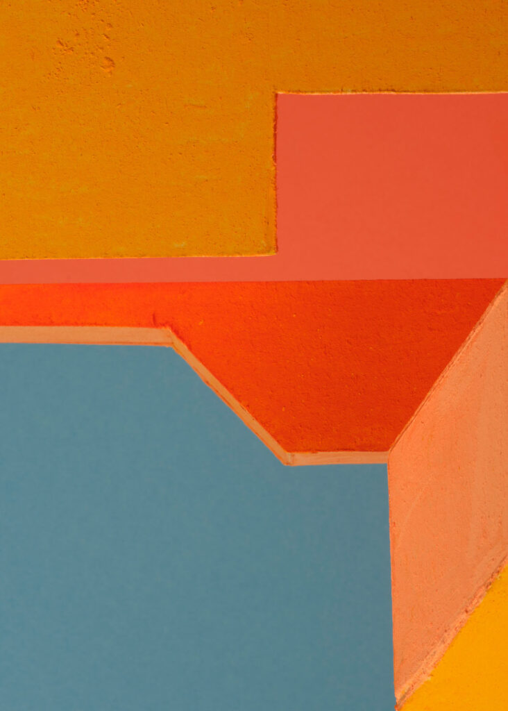 abstract colour study with geometric plaster forms in orange, pink, blue and yellow exploring shifting colour relationships and spatial perception
