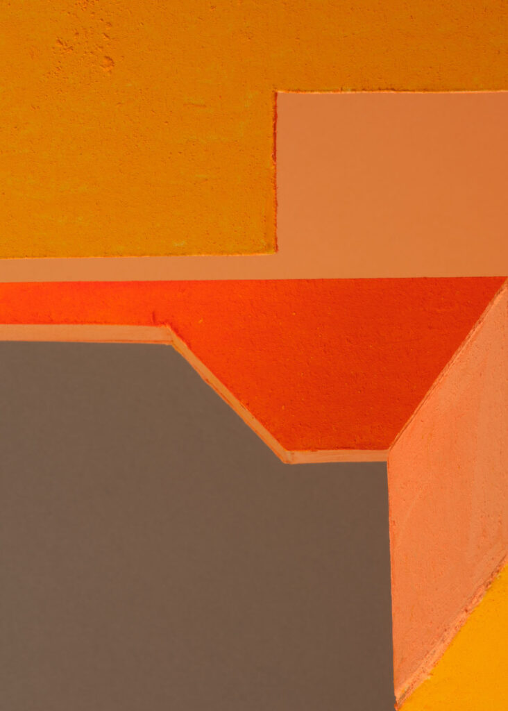 abstract colour study with geometric plaster forms in orange, pink, blue and yellow exploring shifting colour relationships and spatial perception